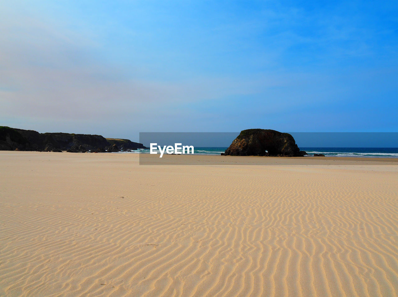 Scenic view of beach against blue sky