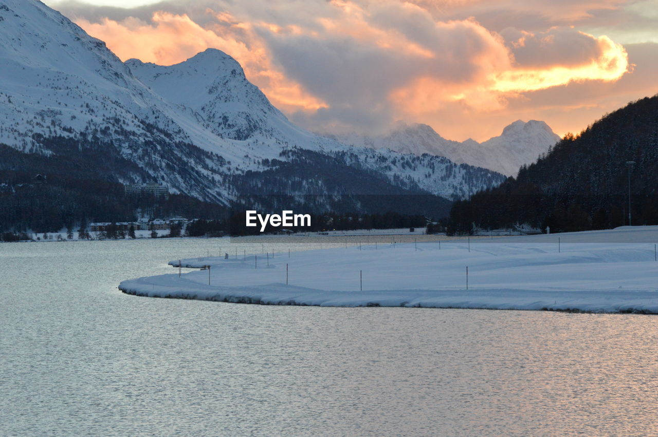 snow, winter, cold temperature, mountain, scenics - nature, environment, landscape, beauty in nature, sky, mountain range, nature, cloud, sunset, tranquil scene, tranquility, land, snowcapped mountain, no people, tree, travel destinations, water, ice, lake, travel, frozen, coniferous tree, plant, non-urban scene, pinaceae, mountain peak, idyllic, pine tree, forest, outdoors, tourism, pine woodland, piste, sun, rural scene