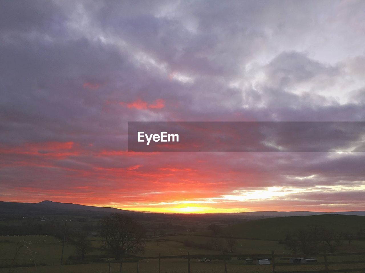 SCENIC VIEW OF LANDSCAPE AGAINST DRAMATIC SKY DURING SUNSET