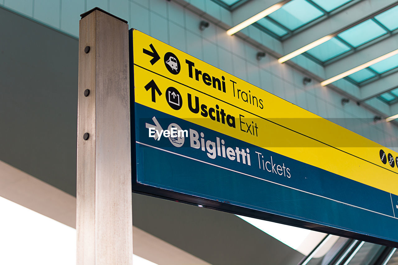 LOW ANGLE VIEW OF INFORMATION SIGN AGAINST YELLOW SKY