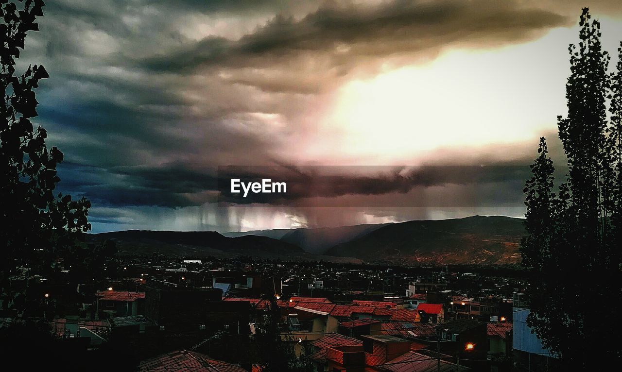 Townscape against cloudy sky during sunset