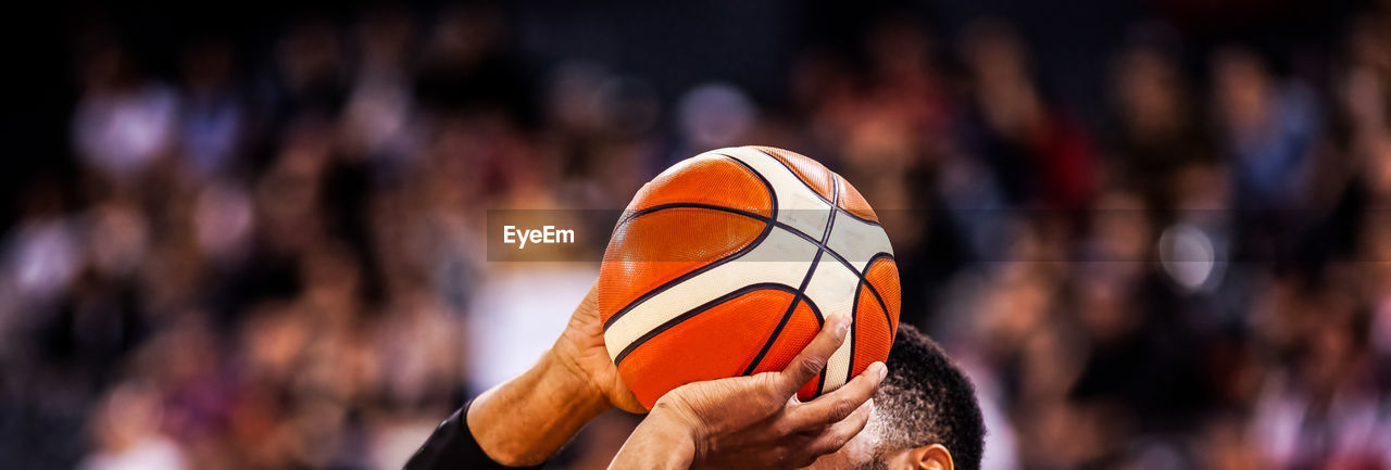 Close-up of hand holding ball against blurred background