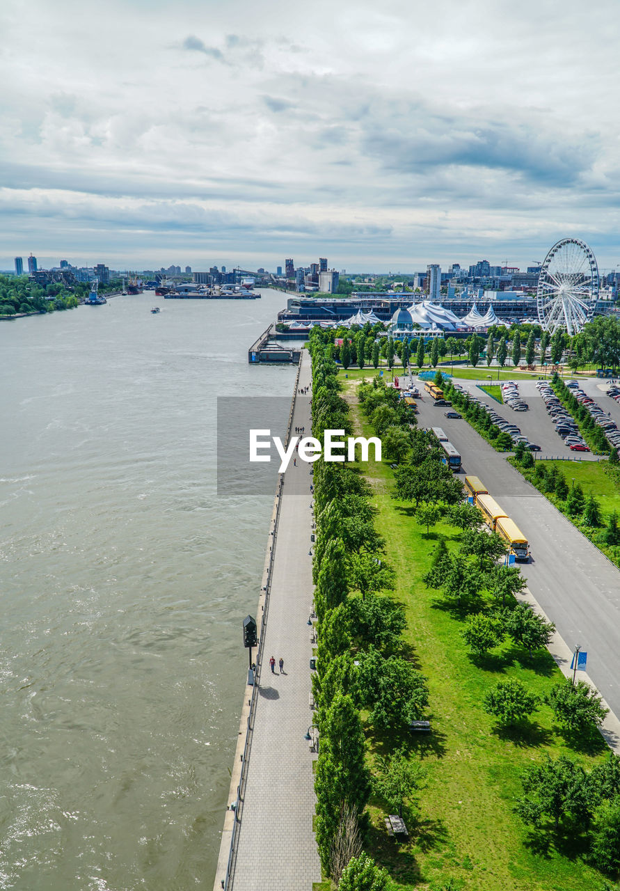 High angle view of city by river against sky