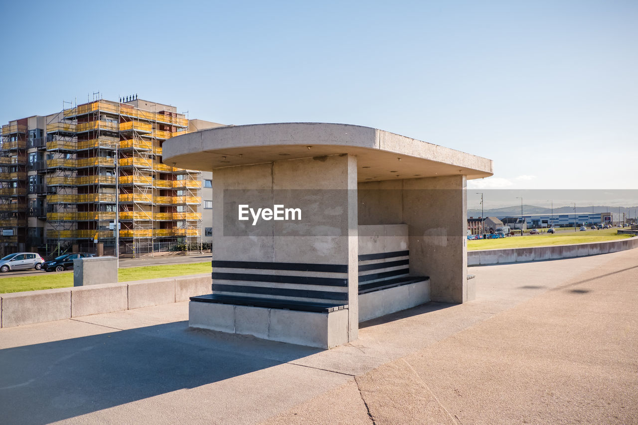 Concrete shelter on promenade against clear blue sky 