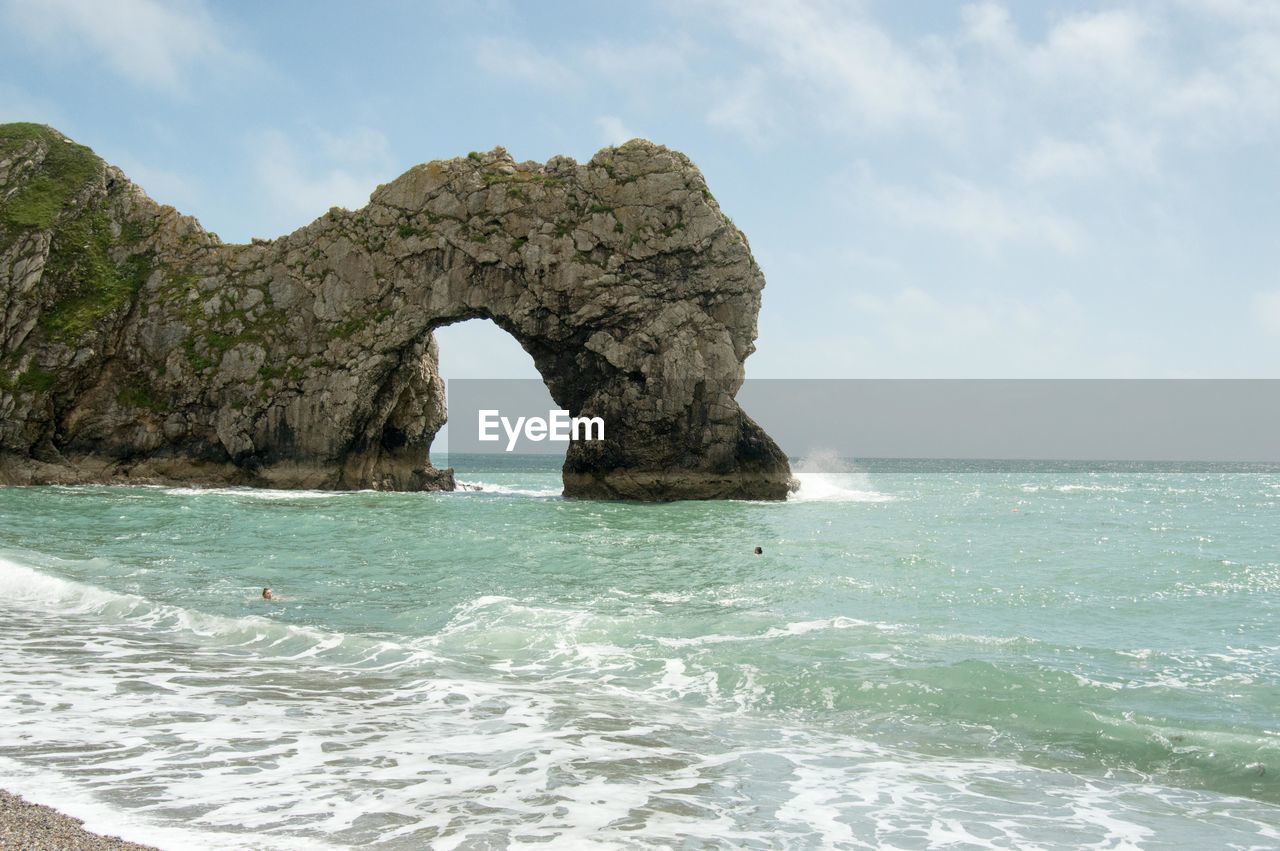 ROCK FORMATIONS IN SEA AGAINST SKY