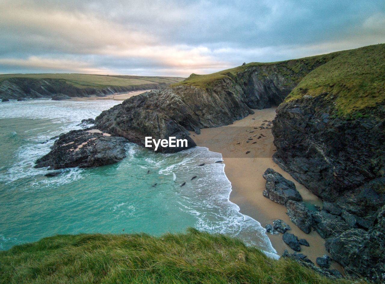 Scenic view of rocks on shore against sky