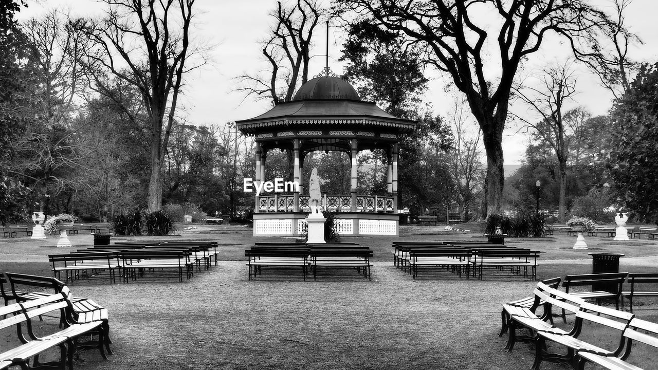 tree, plant, black and white, bench, park, architecture, seat, monochrome photography, monochrome, park - man made space, nature, built structure, day, water, building exterior, park bench, no people, furniture, outdoors, bare tree, sky, gazebo, city, travel destinations