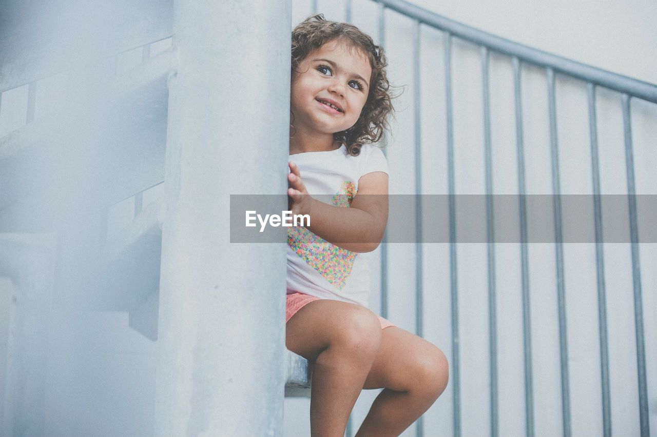 PORTRAIT OF A SMILING GIRL WITH ARMS OUTSTRETCHED