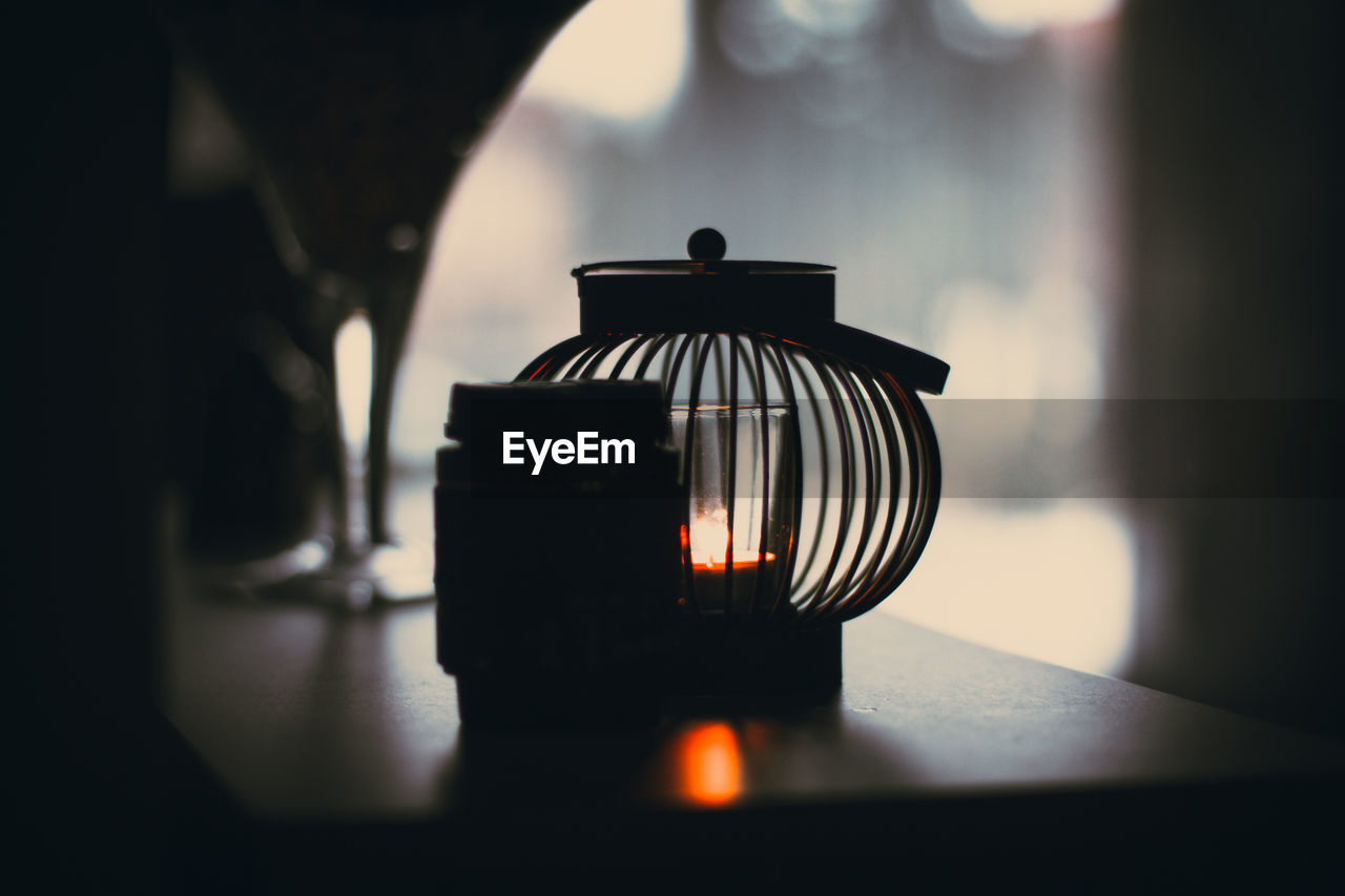 Candle in lantern on table