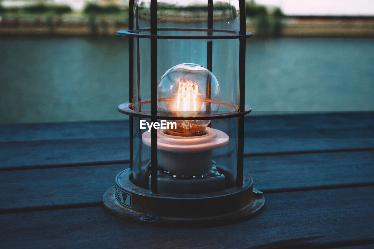 Close-up of illuminated light bulb on table