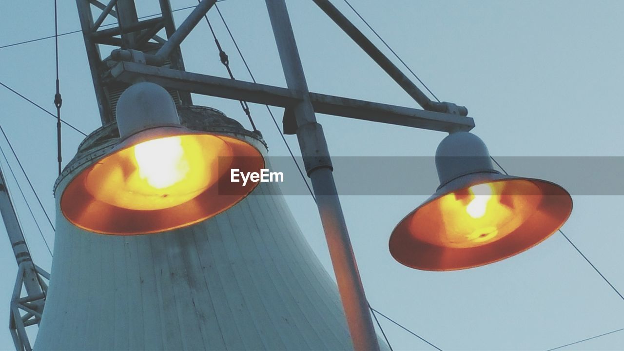 Low angle view of illuminated street light against clear sky