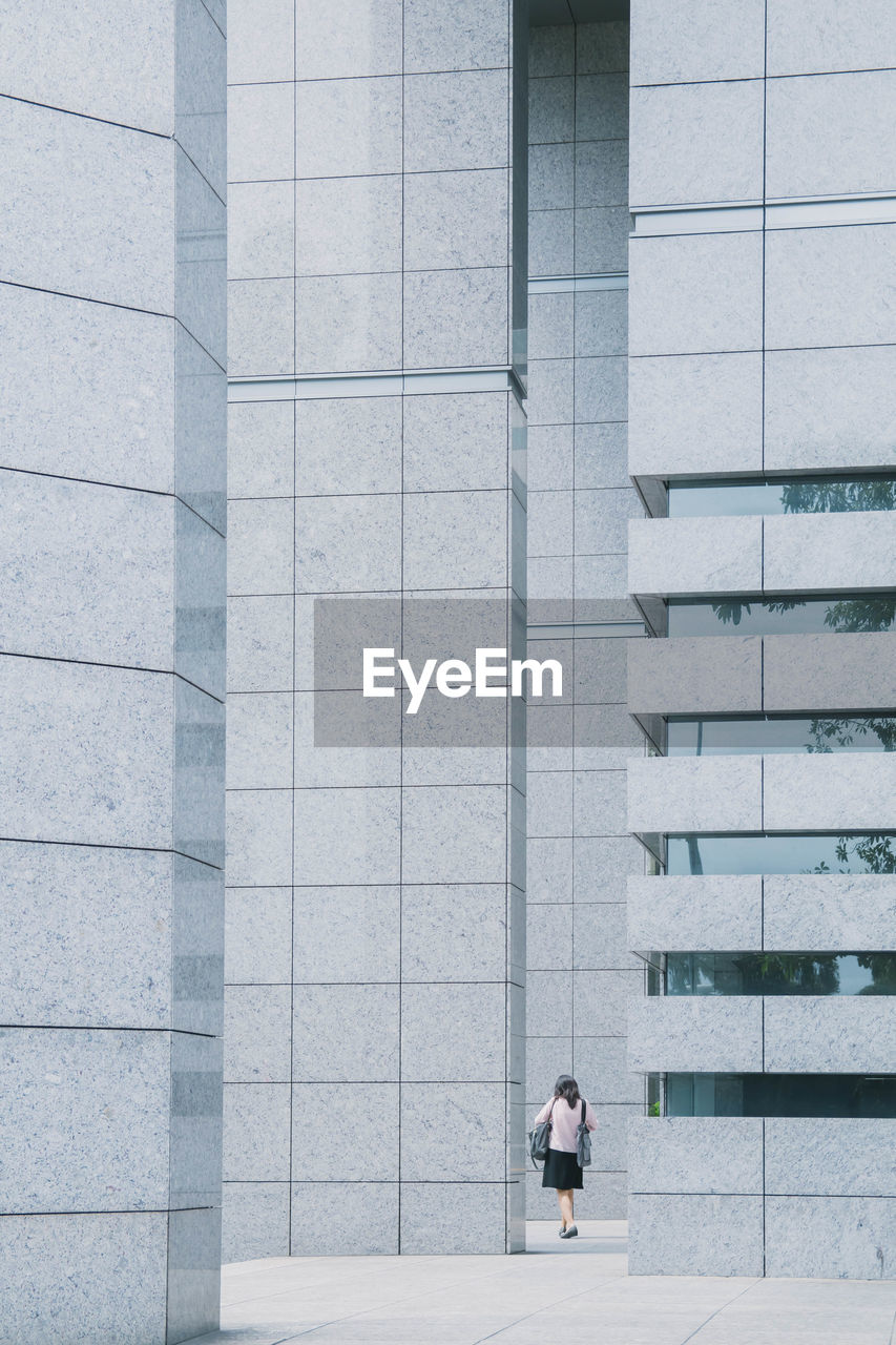 MAN STANDING BY STAIRCASE