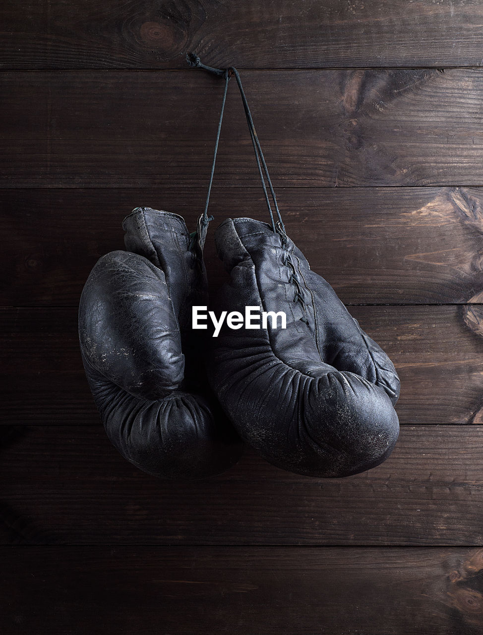 Close-up of boxing gloves hanging on wooden wall