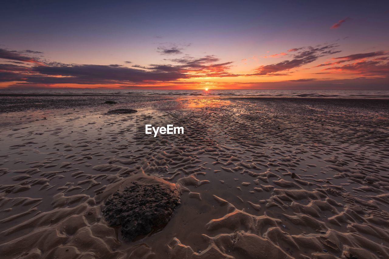 Scenic view of beach against sky during sunset