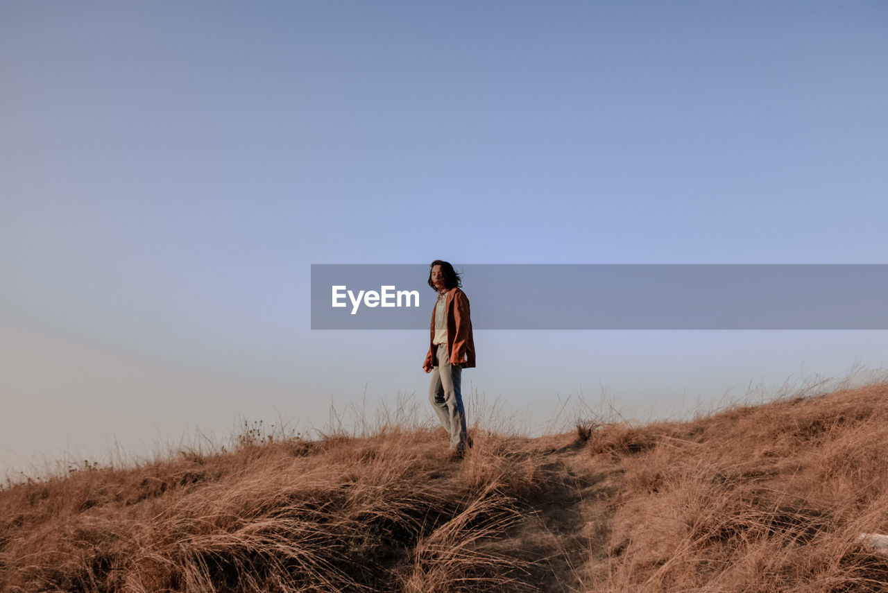 Man standing on field against clear sky