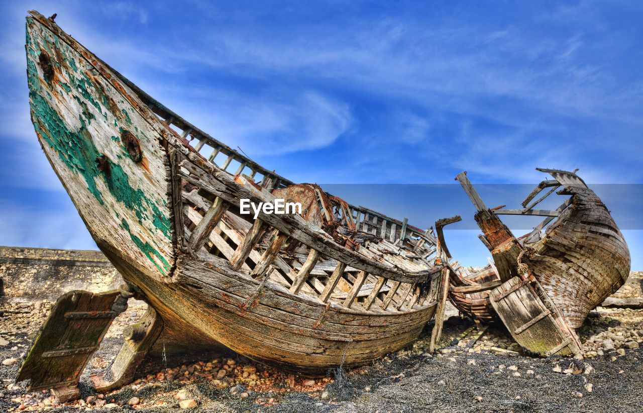 Close-up of abandoned boat against sky