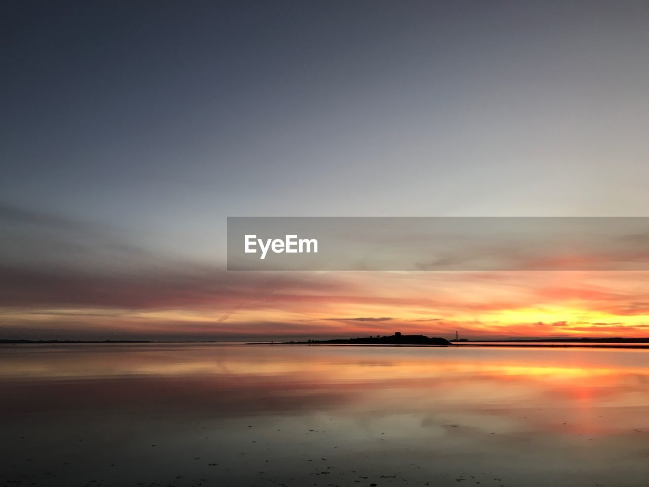 Scenic view of beach against sky during sunset