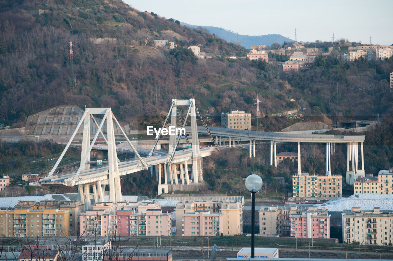 BRIDGE BY BUILDINGS IN CITY