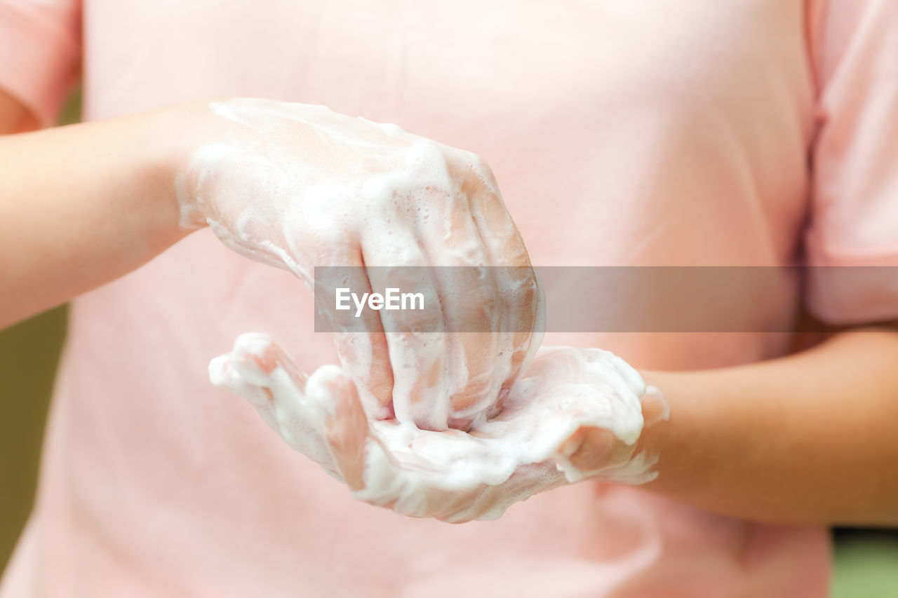 Front view on womans hands with soap foam, personal hygiene concept