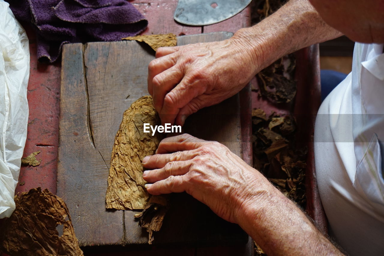 HIGH ANGLE VIEW OF MAN PREPARING FOOD