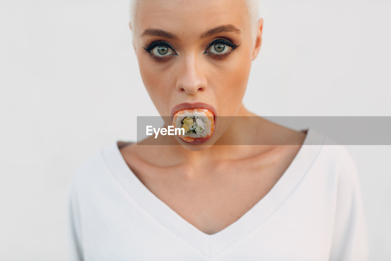 Portrait of young woman against white background