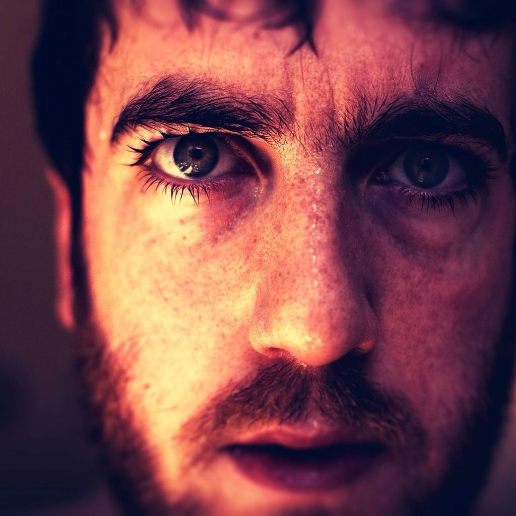 Close-up portrait of sweaty man staring