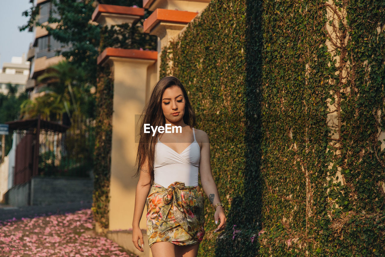 Woman walking by built structure