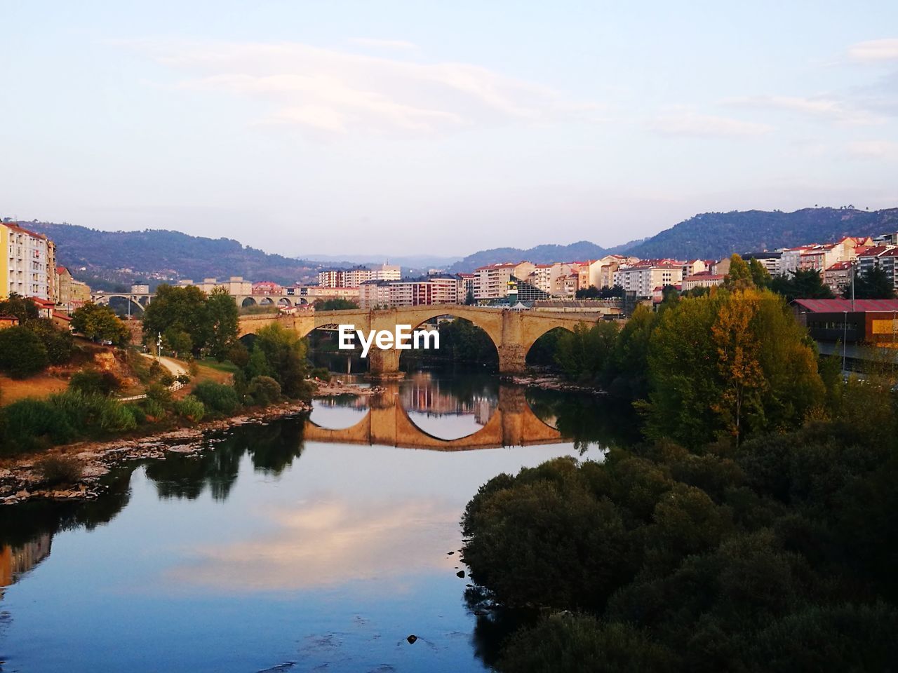 Arch bridge over river against sky