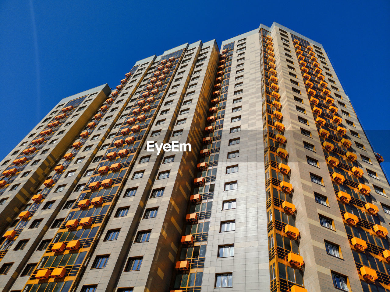 Low angle view of modern building against clear blue sky