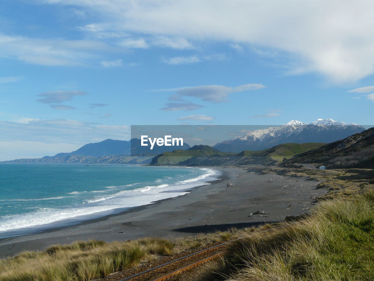 Scenic view of black sand beach against sky