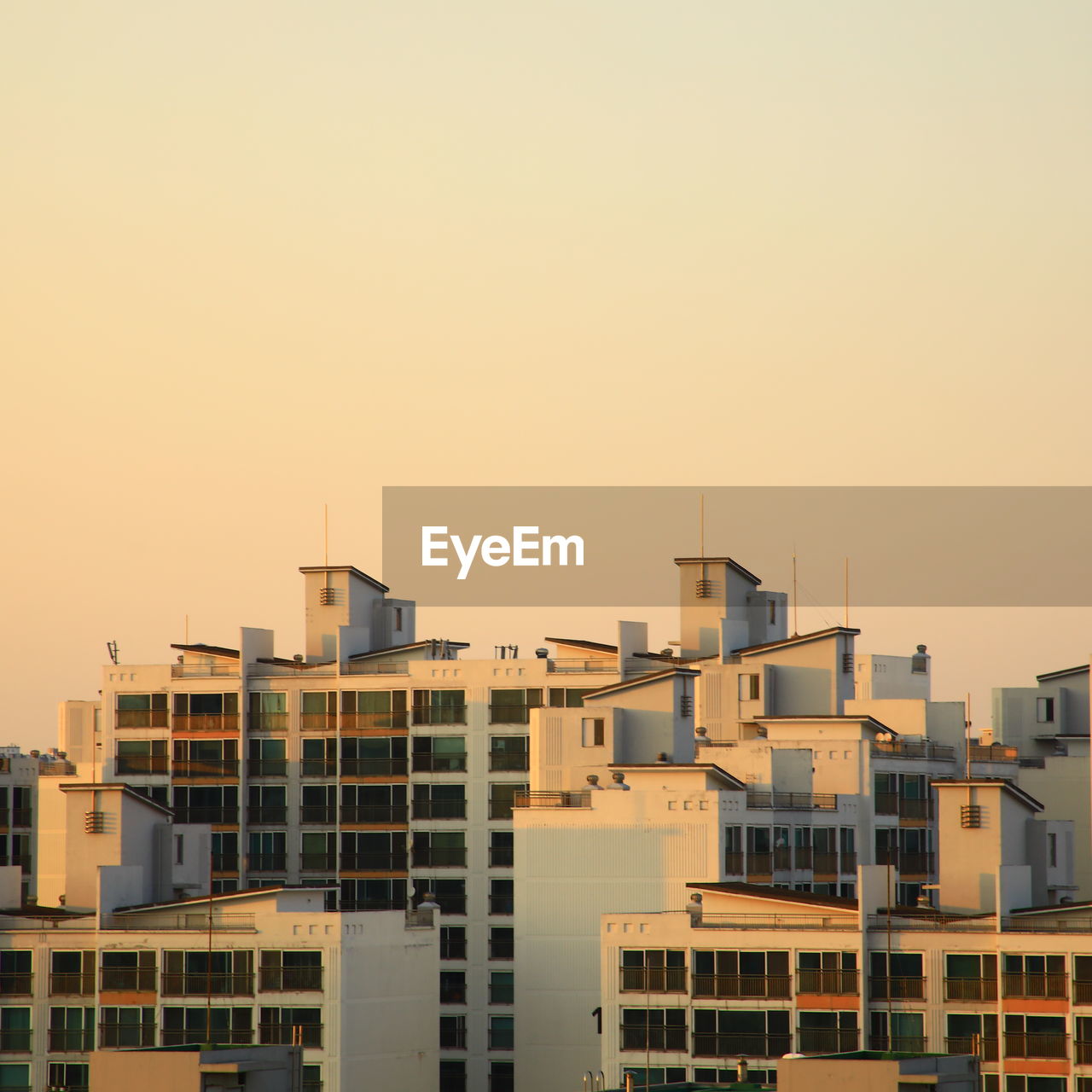 buildings in city against clear sky during sunset