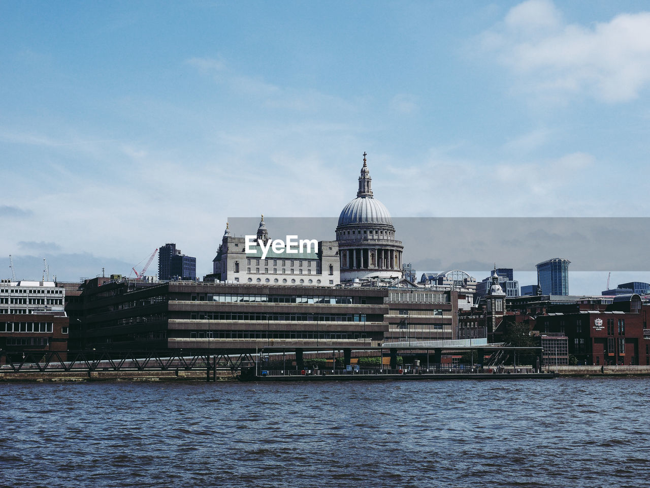 RIVER BY BUILDINGS AGAINST SKY