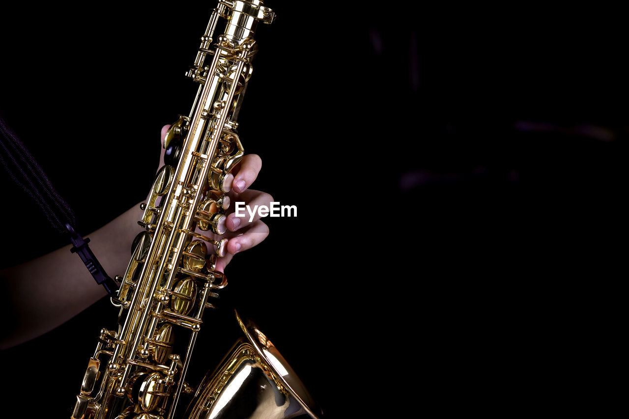 LOW ANGLE VIEW OF HAND PLAYING AT BLACK BACKGROUND