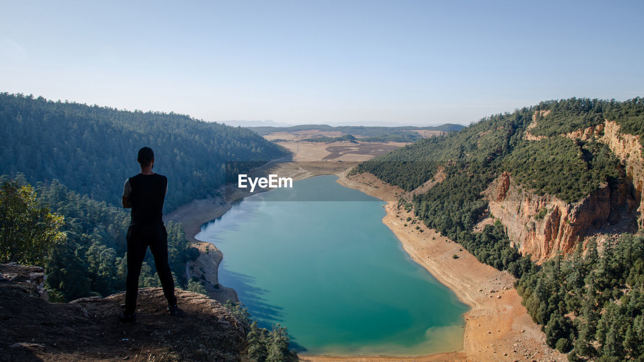 Hiking man looking at aguelmam azigza lake 