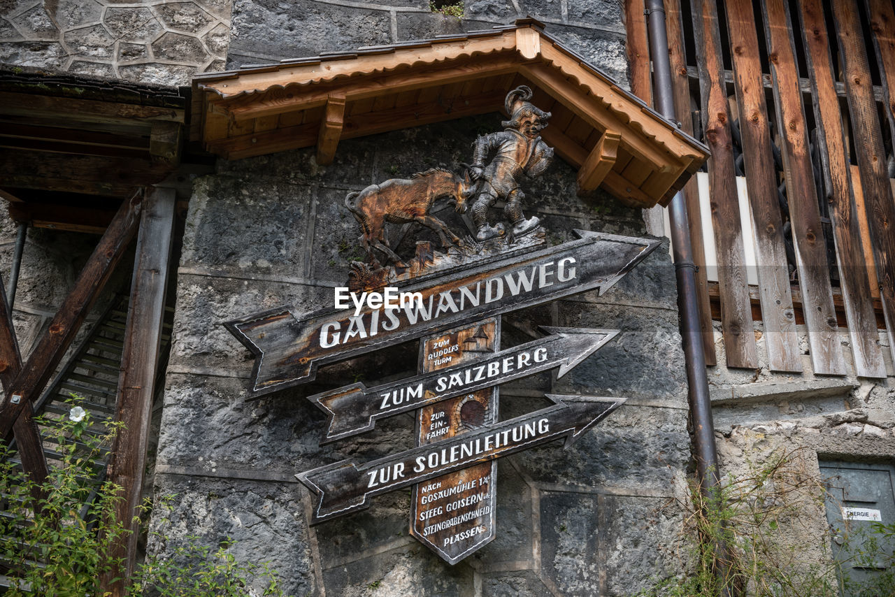 LOW ANGLE VIEW OF TEXT ON ROOF AGAINST BUILDING