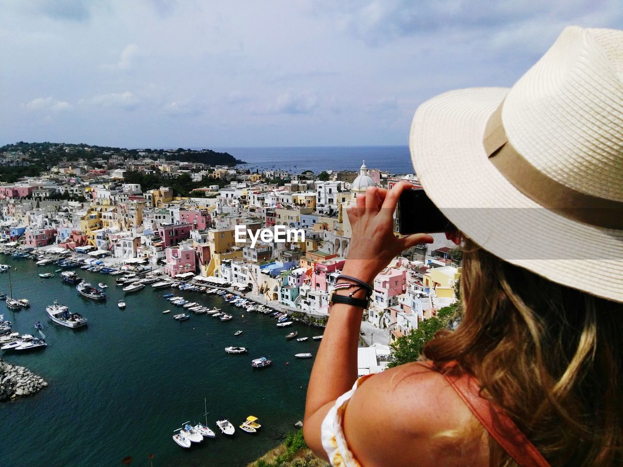 Woman photographing sea and cityscape