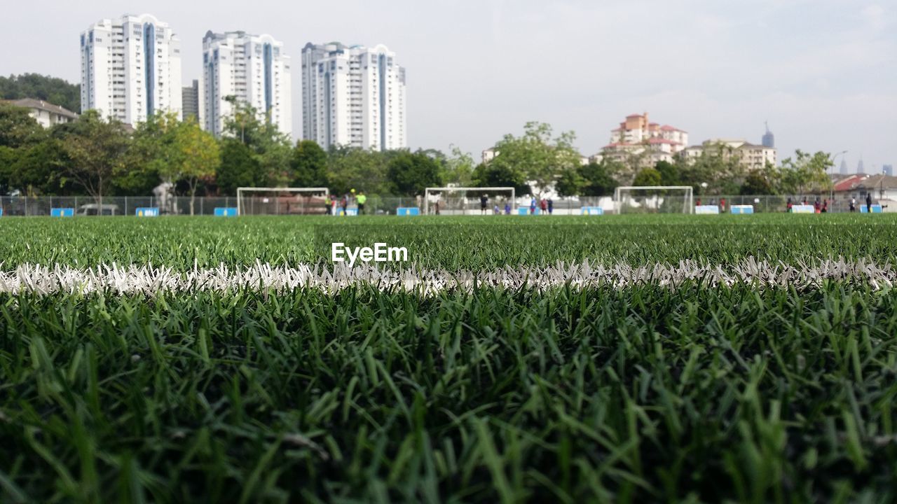 Scenic view of field by buildings against sky