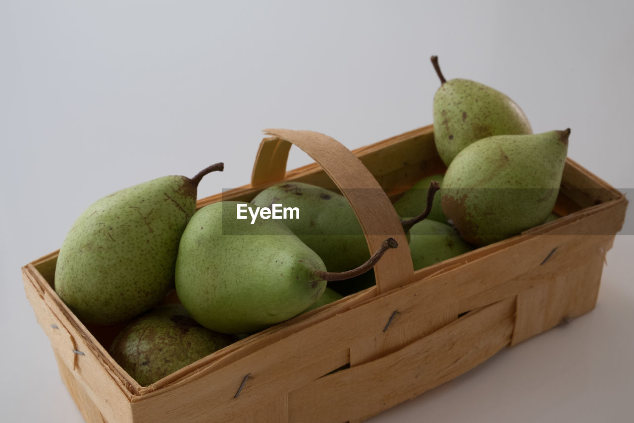 Close-up of fresh green pears in wooden basket