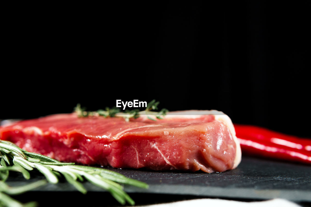 close-up of sushi on cutting board against black background
