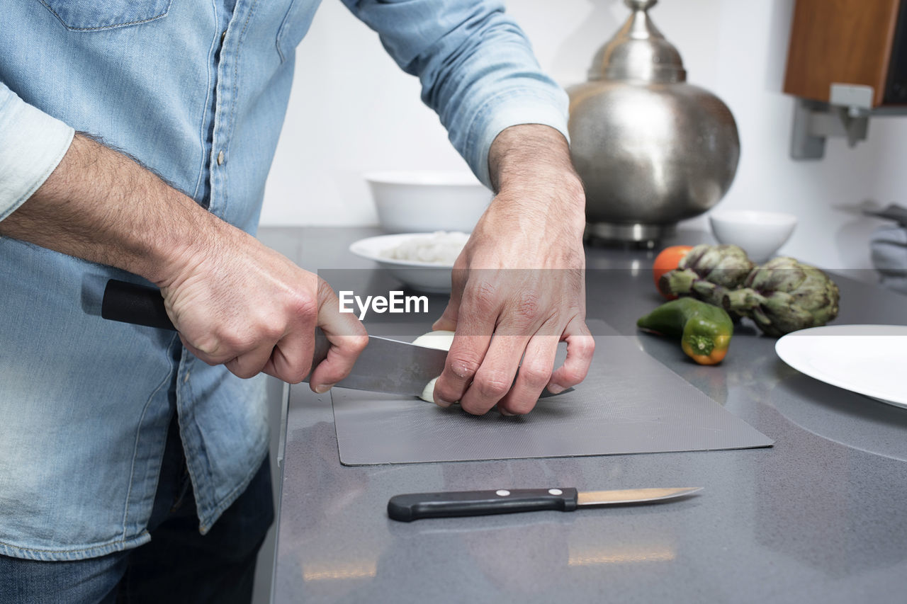 MIDSECTION OF MAN PREPARING FOOD