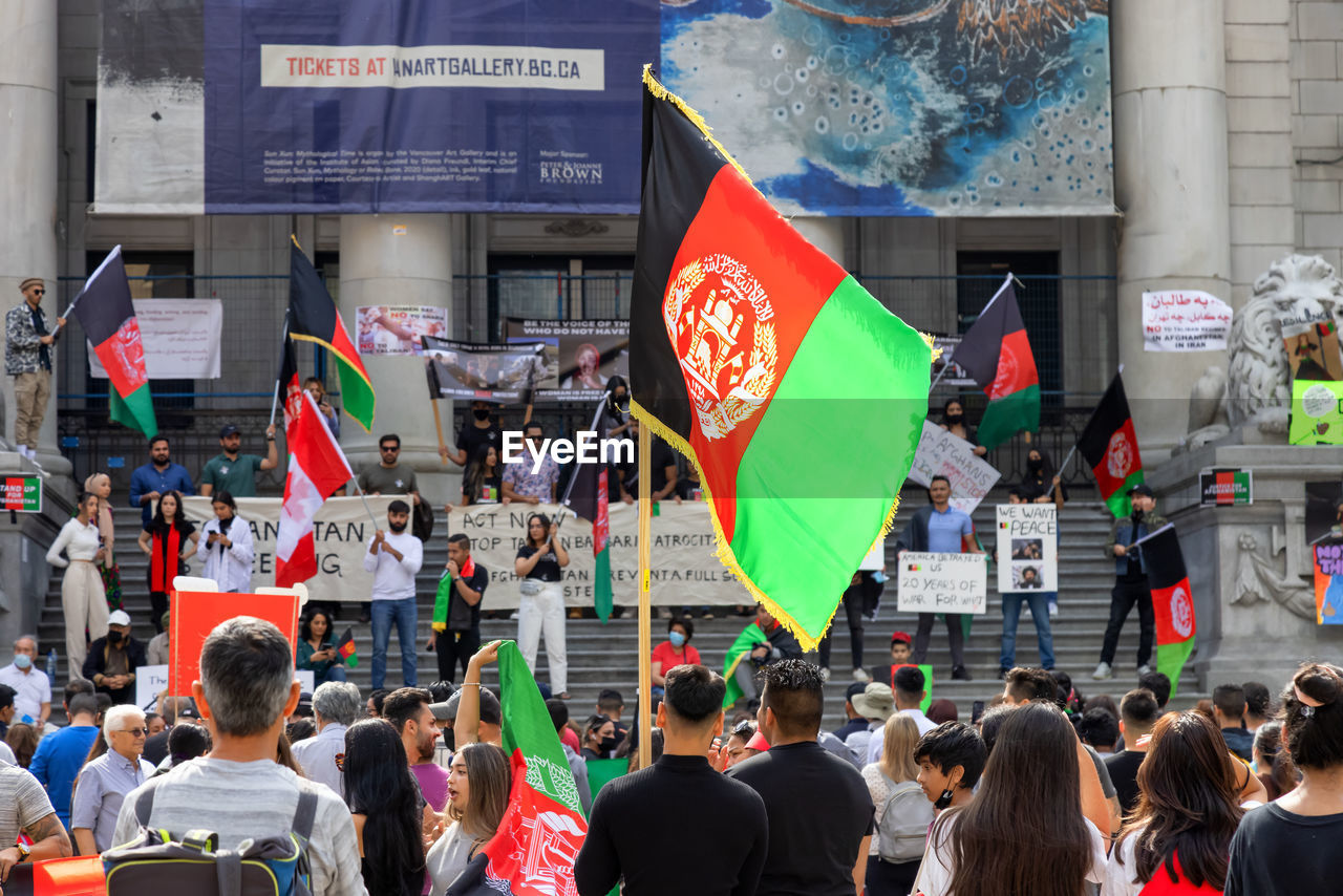 GROUP OF PEOPLE IN FRONT OF FLAGS