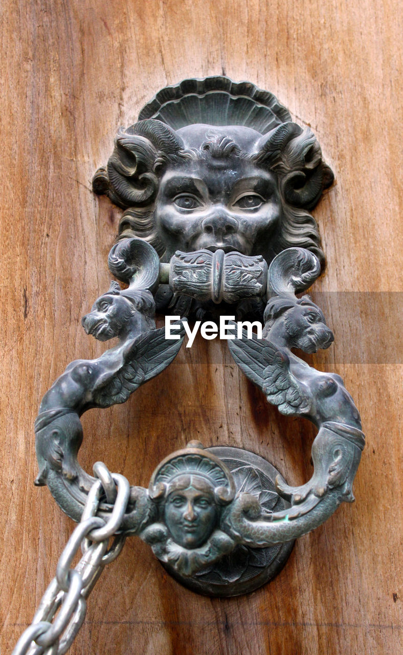 CLOSE-UP OF DOOR KNOCKER ON WOOD