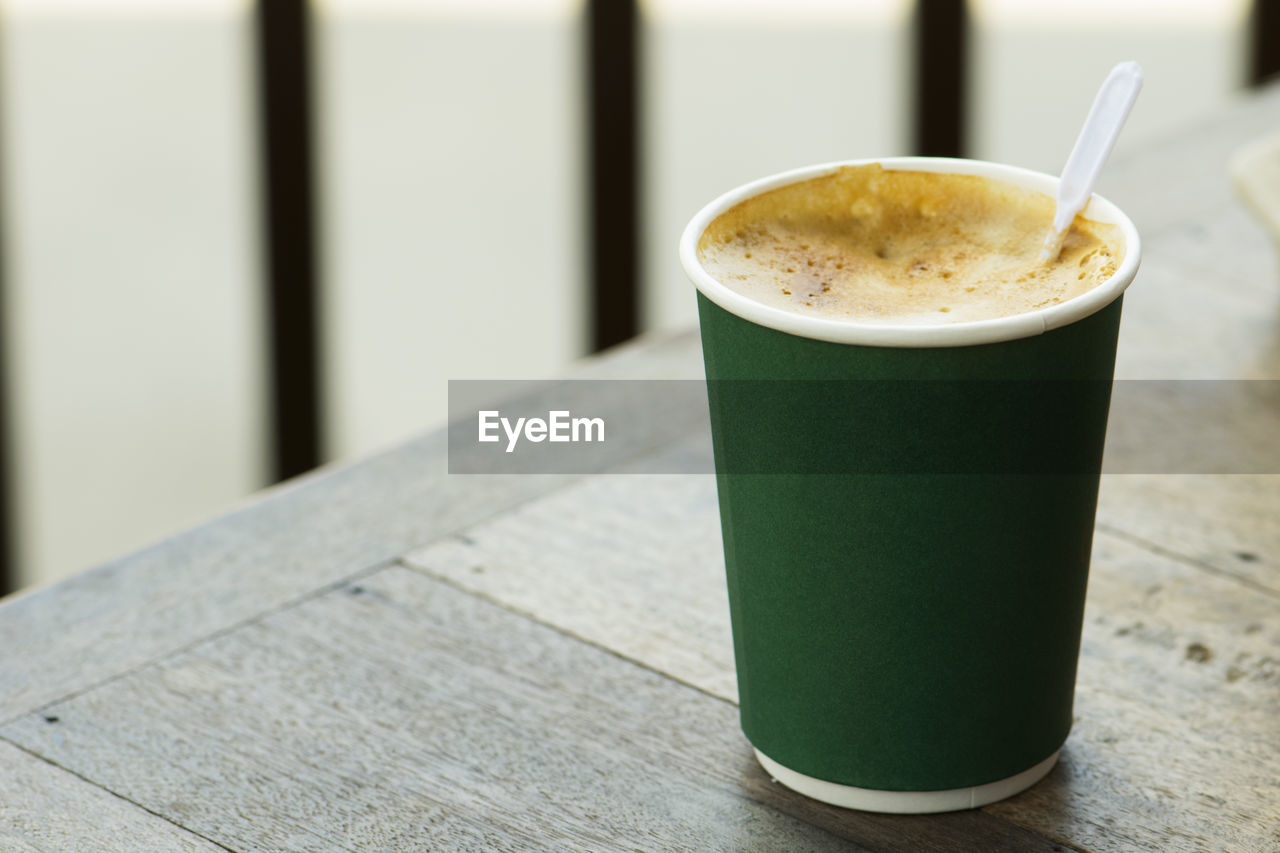 CLOSE-UP OF COFFEE CUP ON GLASS