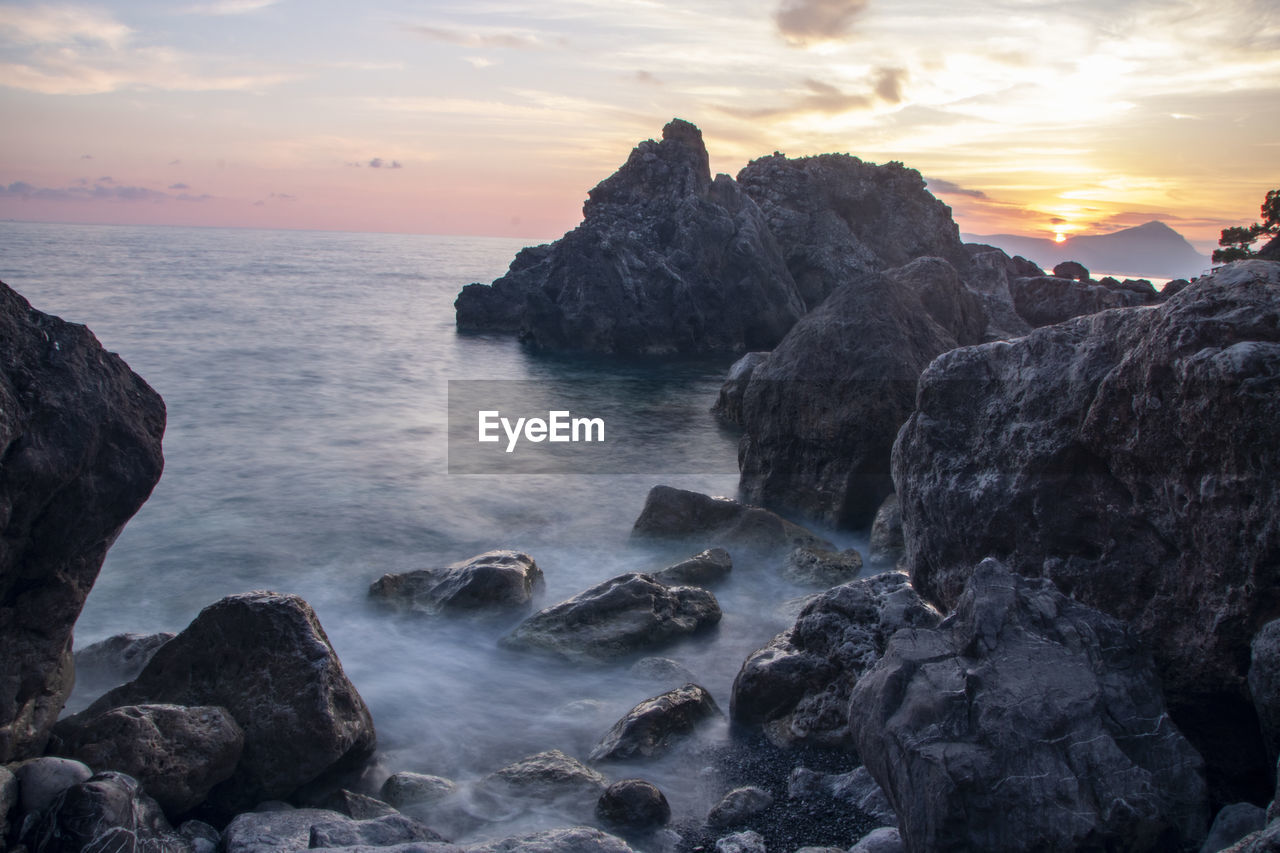 ROCKS ON SEA SHORE AGAINST SKY