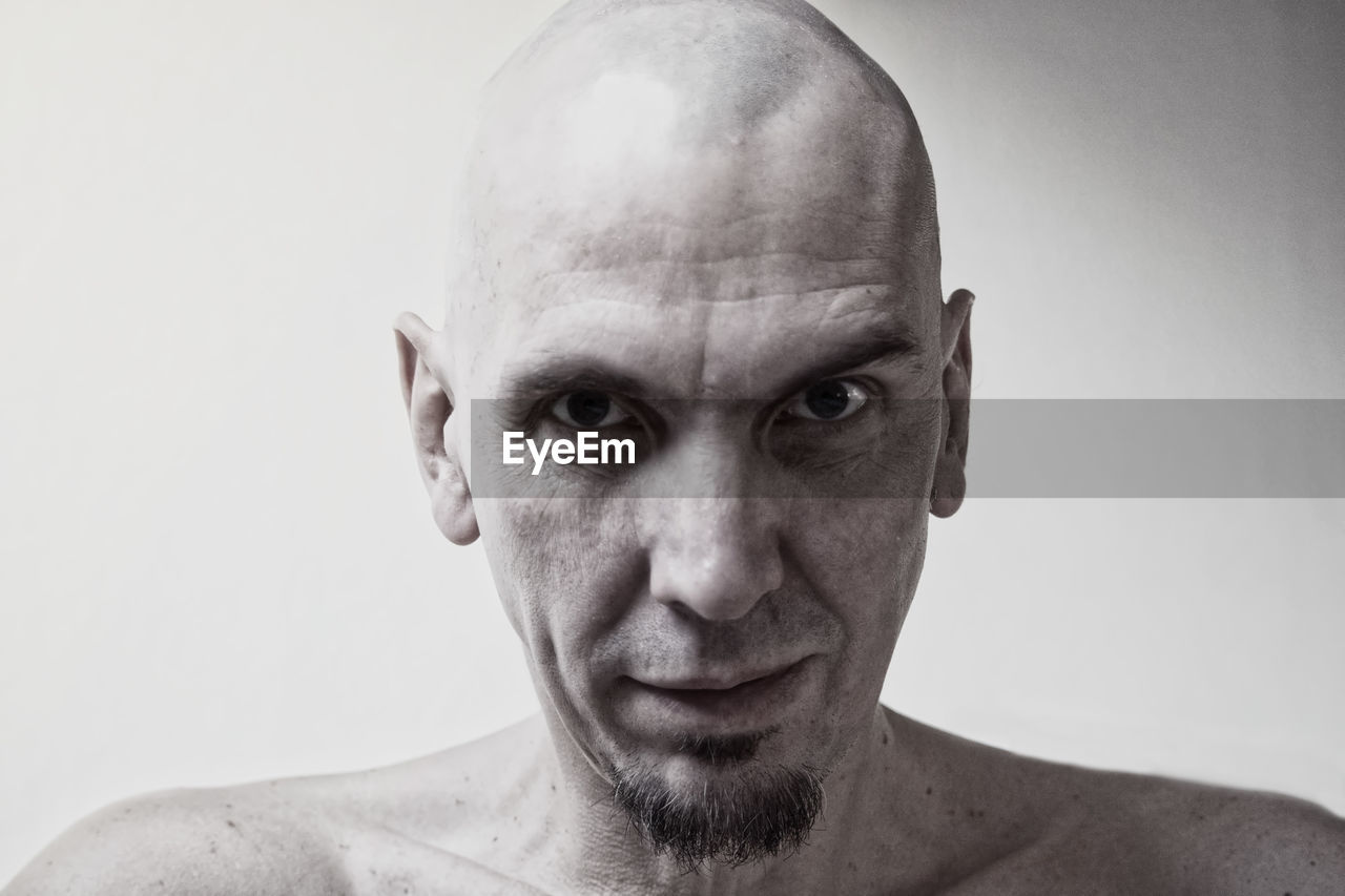 Portrait of shirtless man against white background