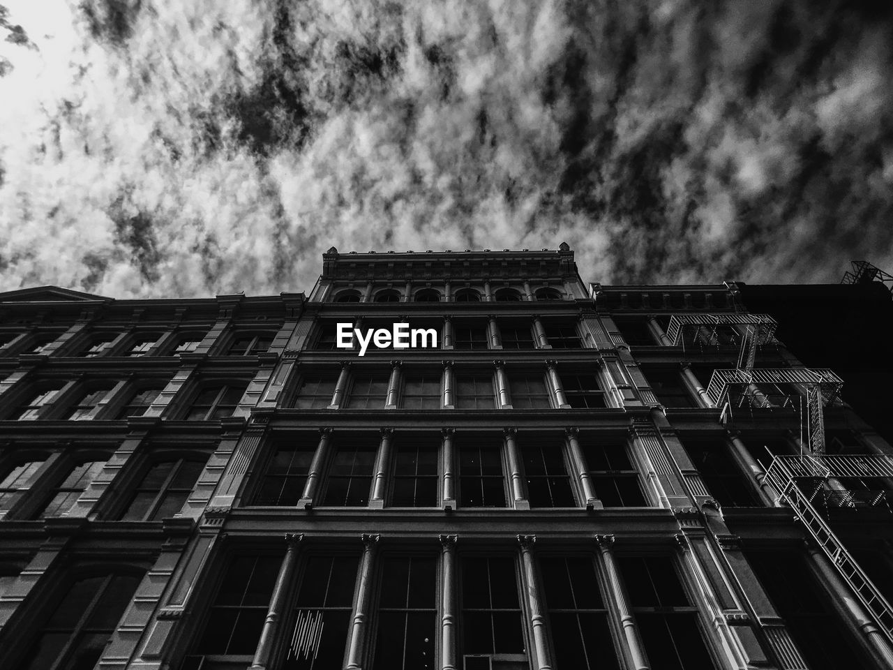 LOW ANGLE VIEW OF BUILDINGS AGAINST CLOUDY SKY