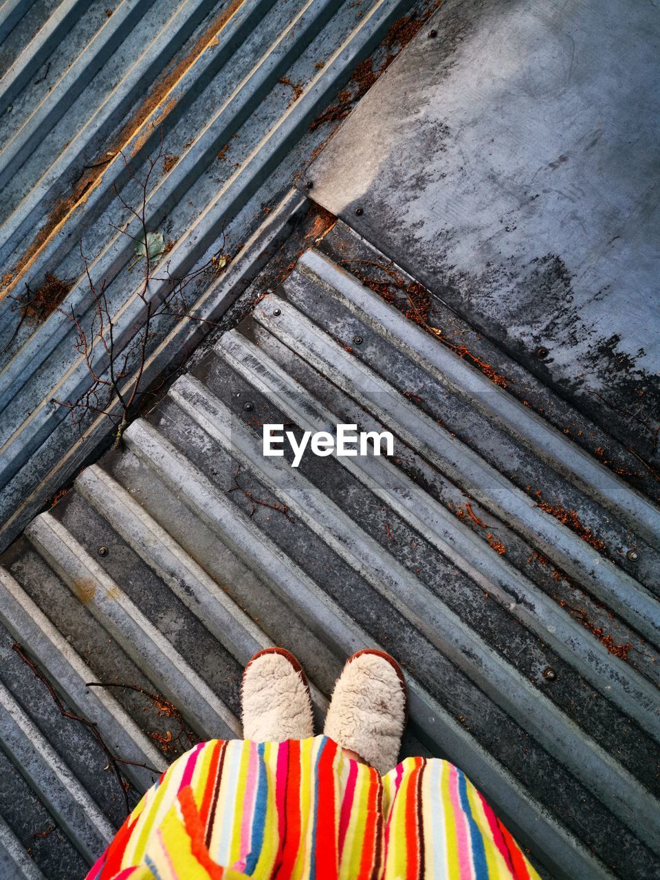 HIGH ANGLE VIEW OF PERSON STANDING ON STAIRCASE