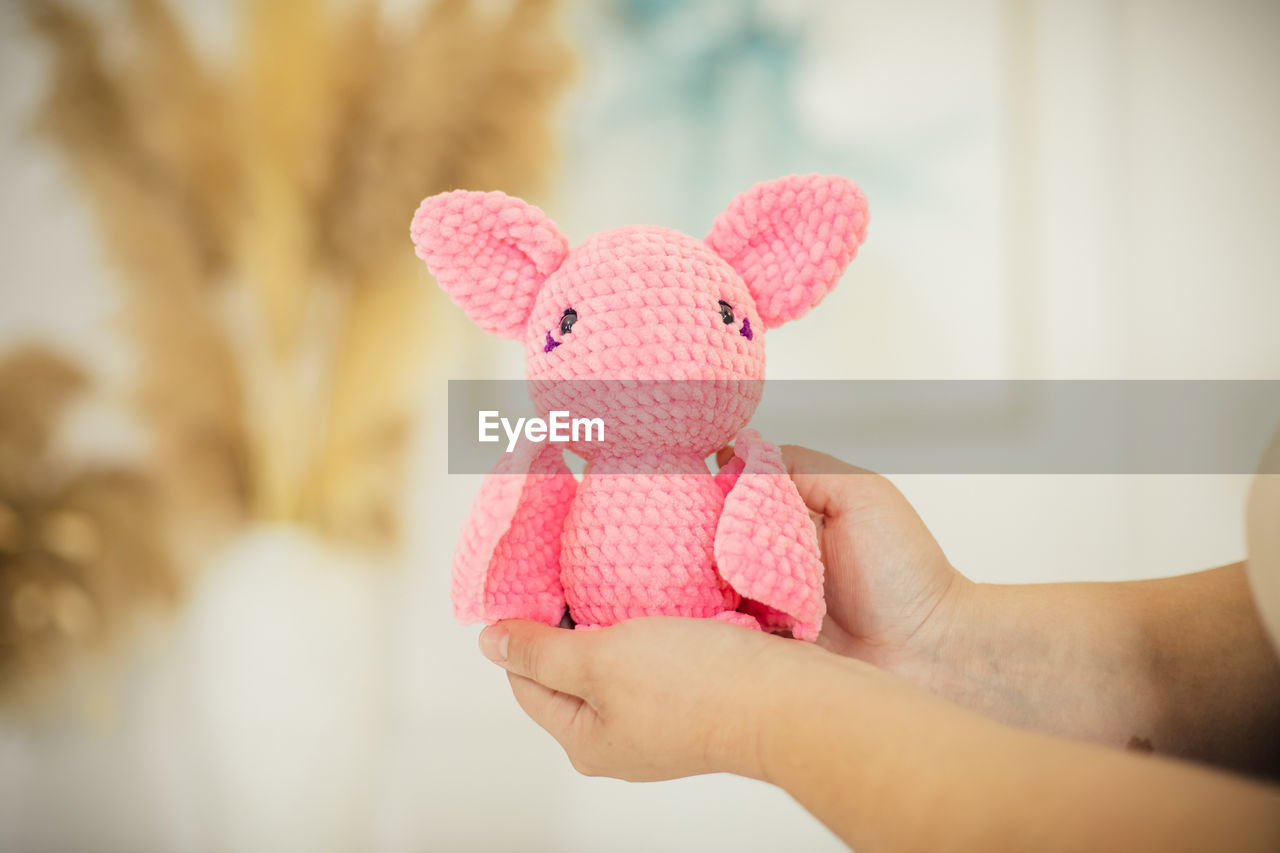 cropped hand of woman holding teddy bear