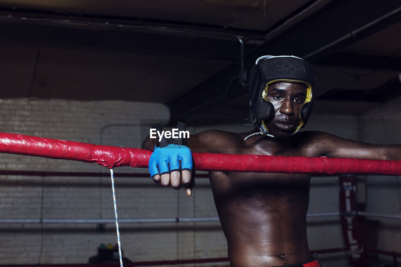 Boxer looking away while standing in boxing ring