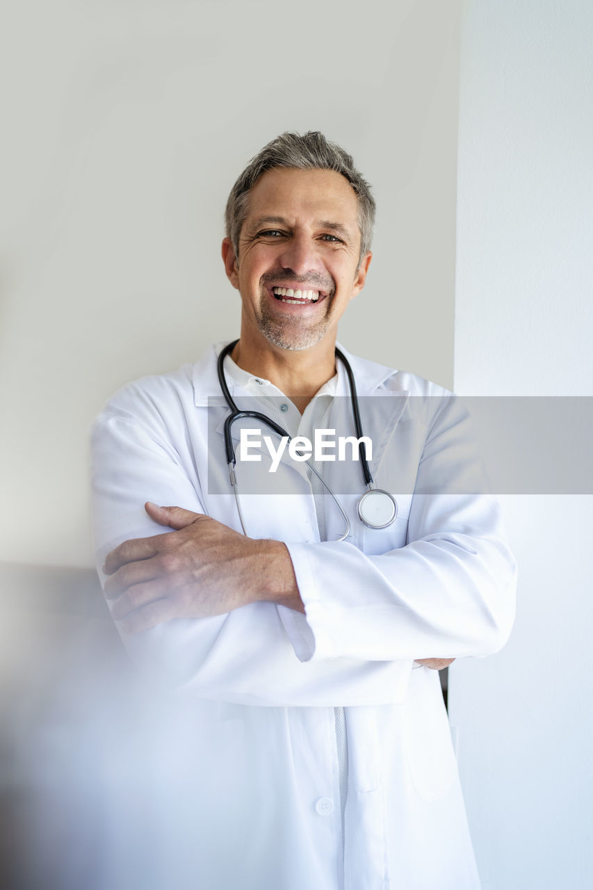 Portrait of happy doctor with arms crossed